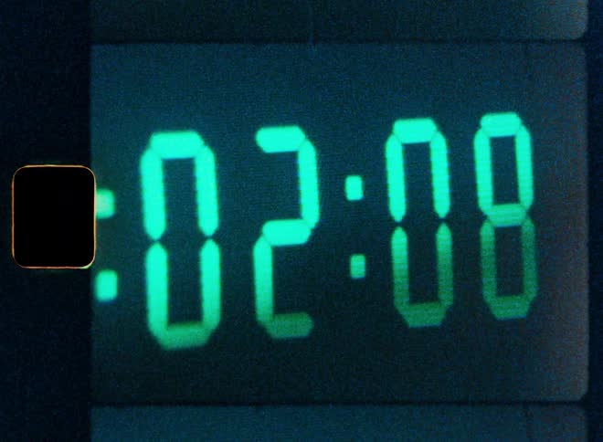 Super 8mm film of a vintage green digital timer rapidly counting down to zero