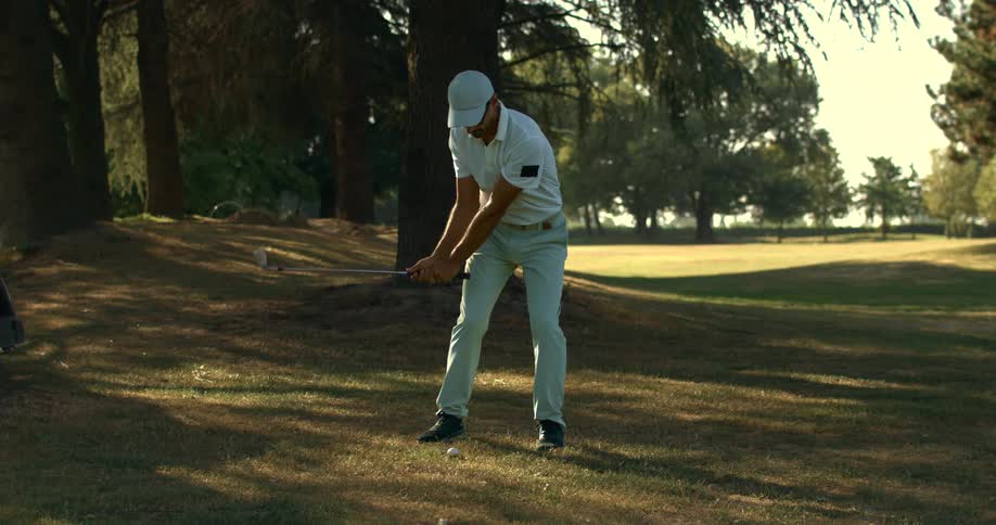 Super slow-motion footage captures a male golfer's perfect iron shot on a sunlit fairway