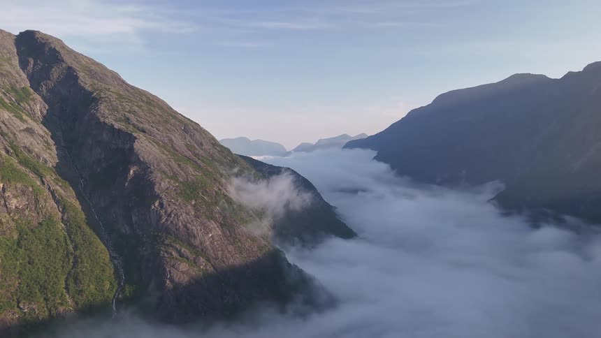 Serene aerial view of a majestic mountain valley covered by a sea of clouds