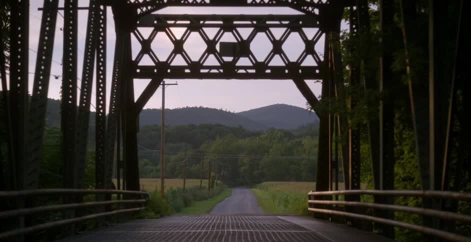 A rural bridge is shown in the summer