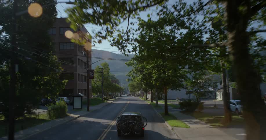 An suv carrying bicycles drives down a street