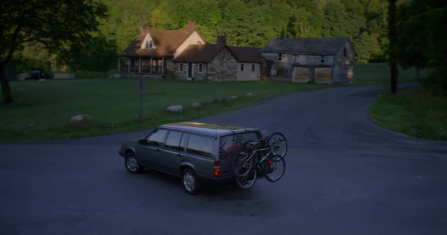 A station wagon turns down the road