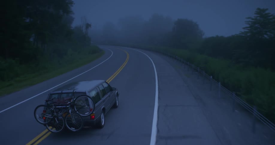 Car driving down a country road at night
