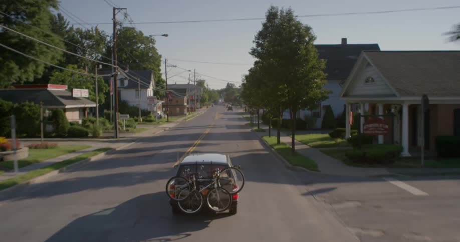 A car drives down a road with bikes on the back