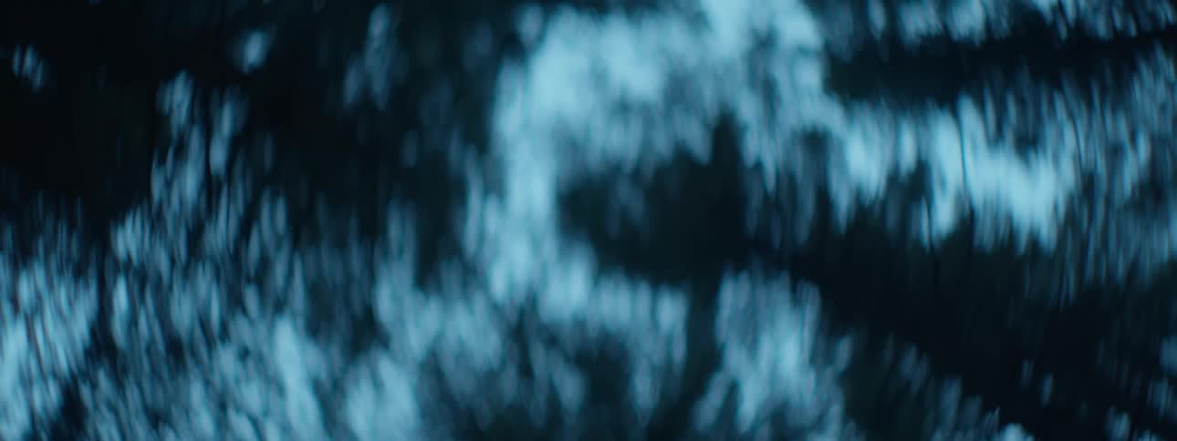 Gentle movement of blue and black bokeh light patterns creates a serene and abstract background