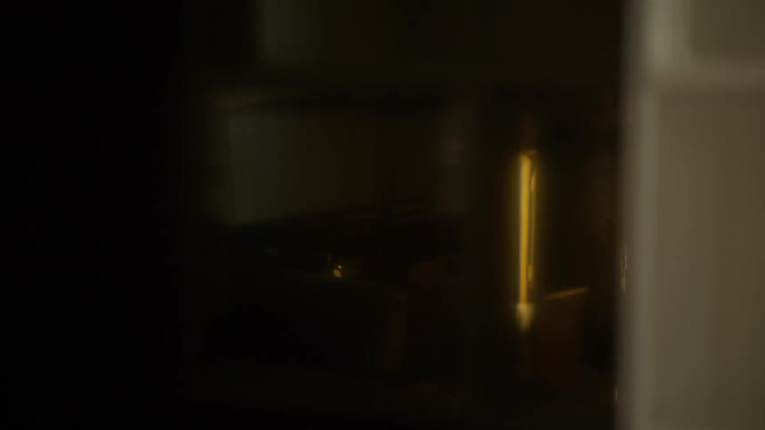 Abstract shot of a dim, warm light fading at the end of a dark, out-of-focus corridor