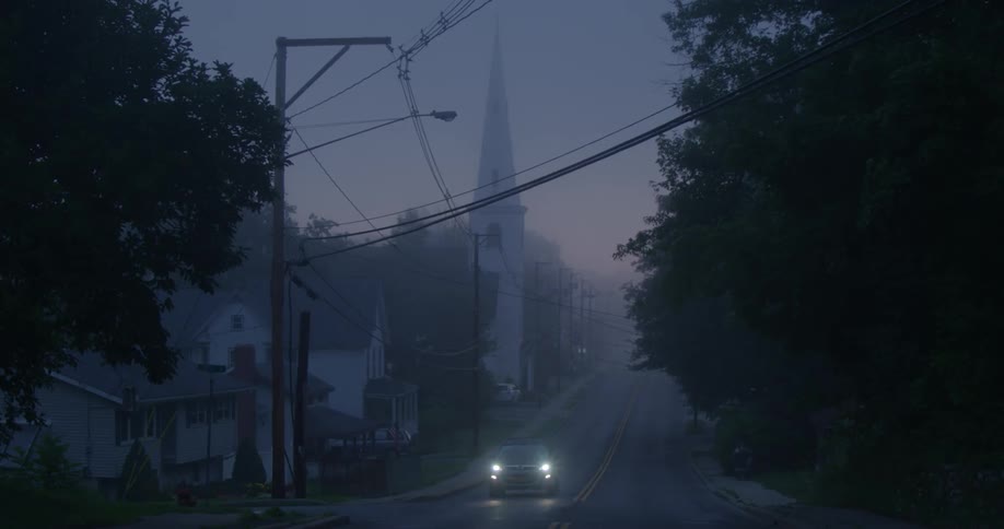 Car driving down a country road at night