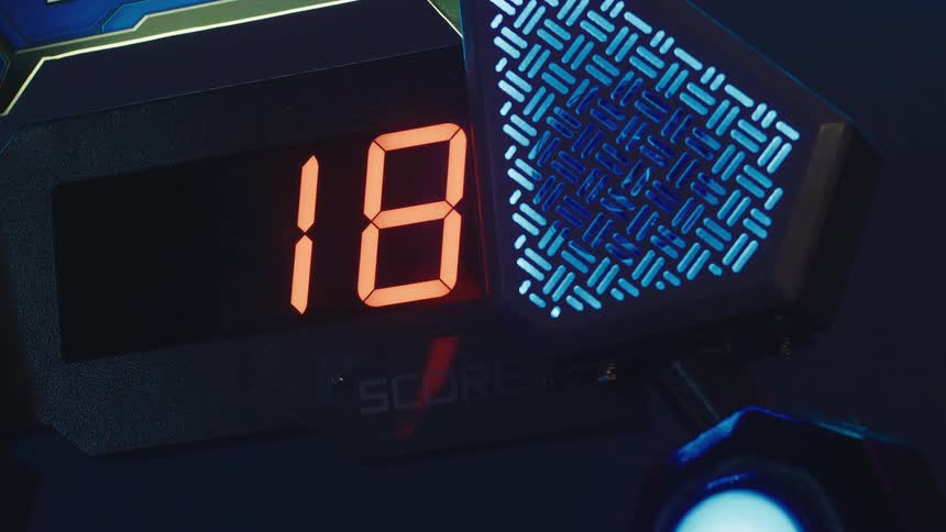 Close-up of a futuristic arcade game scoreboard as the points rapidly increase in a dark room