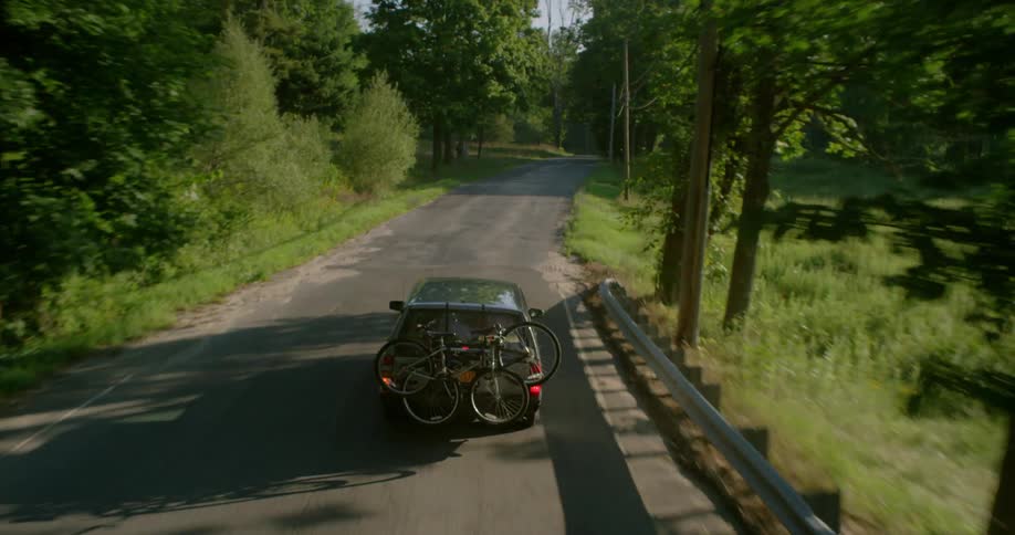 Vehicle driving down a country road carrying bicycles on its rear