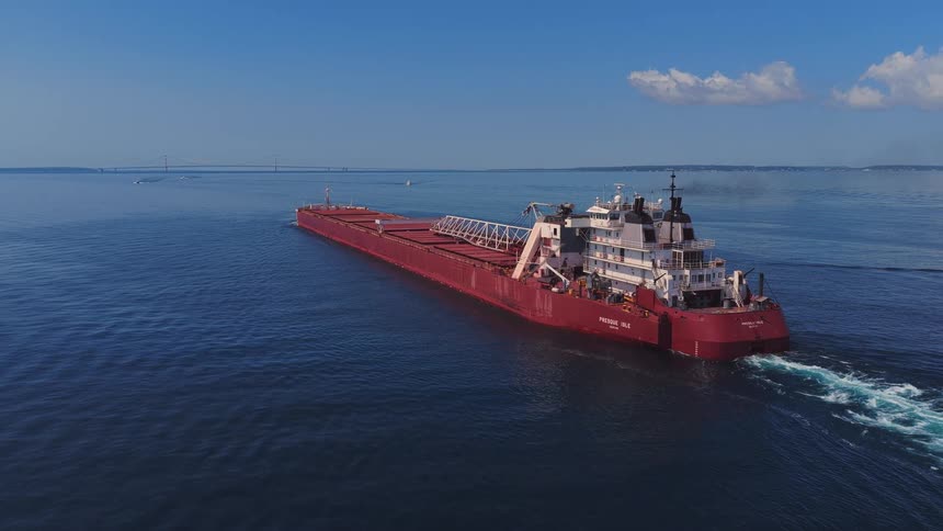 Aerial view of the Presque Isle lake freighter sailing on the Great Lakes towards the Mackinac Bridge on a sunny day