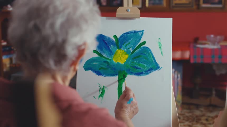 Over the shoulder shot of a multigenerational group of women enjoying a creative painting class at home