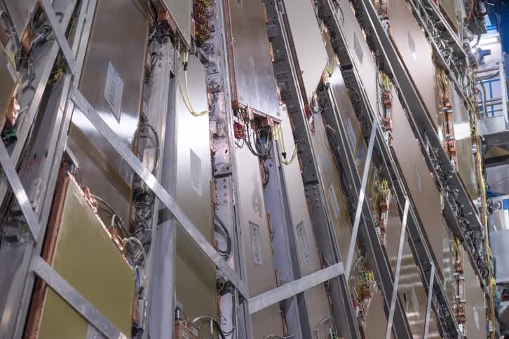 A detailed vertical view of the complex internal machinery of a large particle accelerator at a scientific research facility