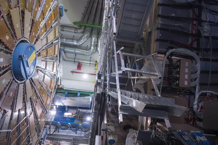 A slow zoom out reveals the complex wiring and massive scale of an underground particle detector at a scientific research facility