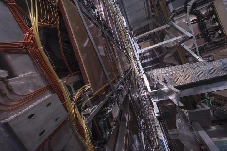 A vertical timelapse captures the complex assembly process of a large-scale scientific or industrial machine