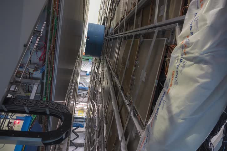 A slow revealing dolly shot of the immense ATLAS particle detector at CERN, showcasing its complex engineering