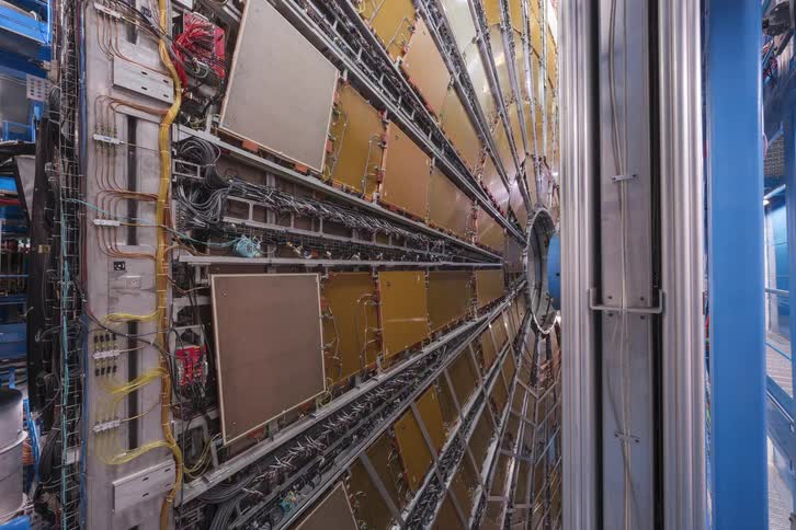 Zooming out from the intricate wiring to reveal the colossal structure of the ATLAS detector at CERN's Large Hadron Collider