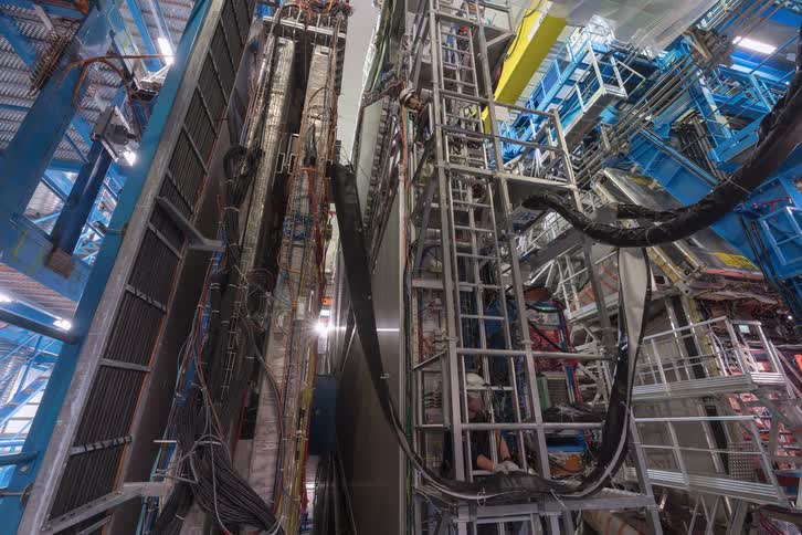 Timelapse of engineers working on the immense and complex machinery of a particle detector at a major scientific research facility