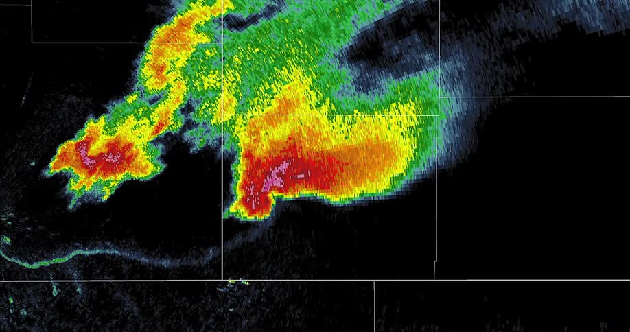 A colorful weather radar screen displays a powerful tornadic supercell thunderstorm moving through the area