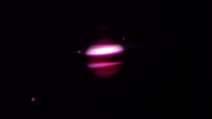 A stylized, glowing pink and purple banded planet, resembling Jupiter, rotates in the vast darkness of space