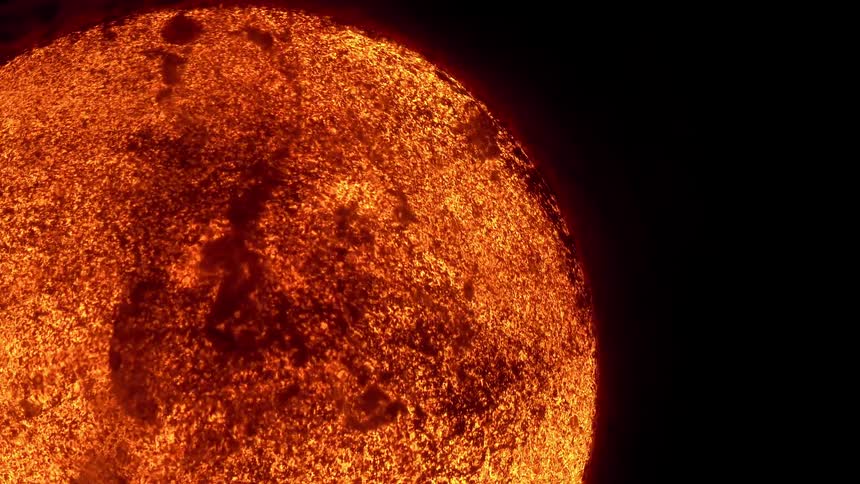 Molten lava flows across the surface of a fiery, glowing planet in deep space