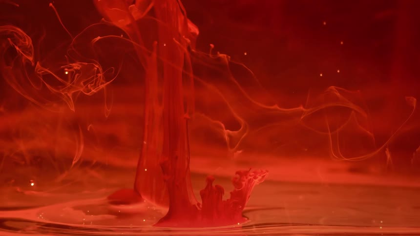 Ethereal red ink blooms and swirls in water, creating a mesmerizing and abstract slow-motion visual