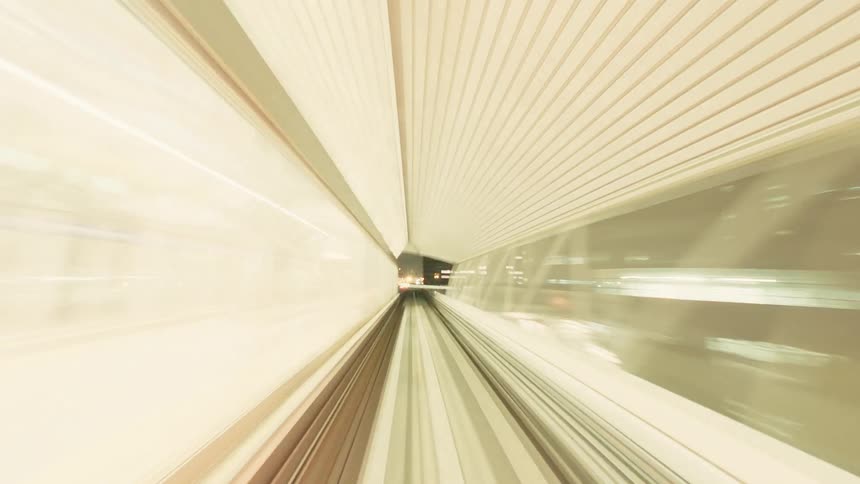 Point-of-view time-lapse of a futuristic monorail journey through an illuminated city at night