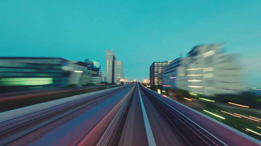 Point-of-view time-lapse of a high-speed train journey through a futuristic city at twilight