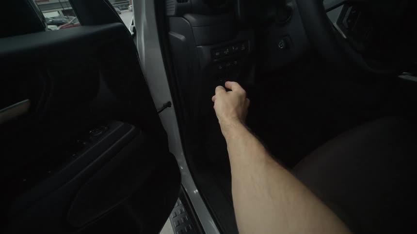A first-person view of opening a modern white truck door and pressing a button on the dashboard