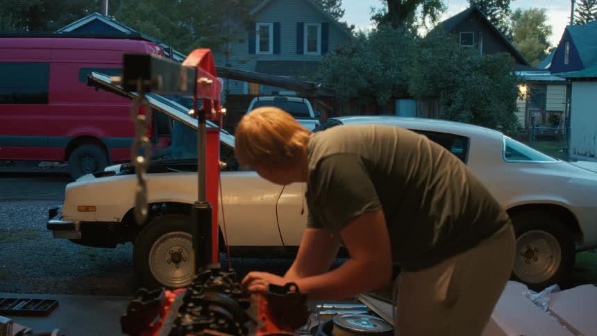 A young man and his grandfather bond while working together to rebuild the engine of a classic muscle car in their garage