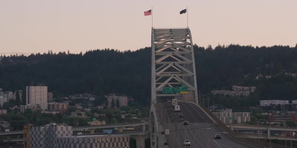 A slow aerial reveal of the Fremont Bridge in Portland, Oregon, showcases traffic moving across the structure at dusk