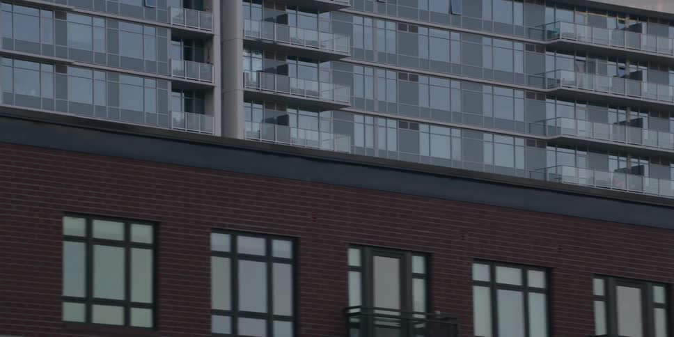 A slow pan across the modern architectural facades of city residential apartment buildings