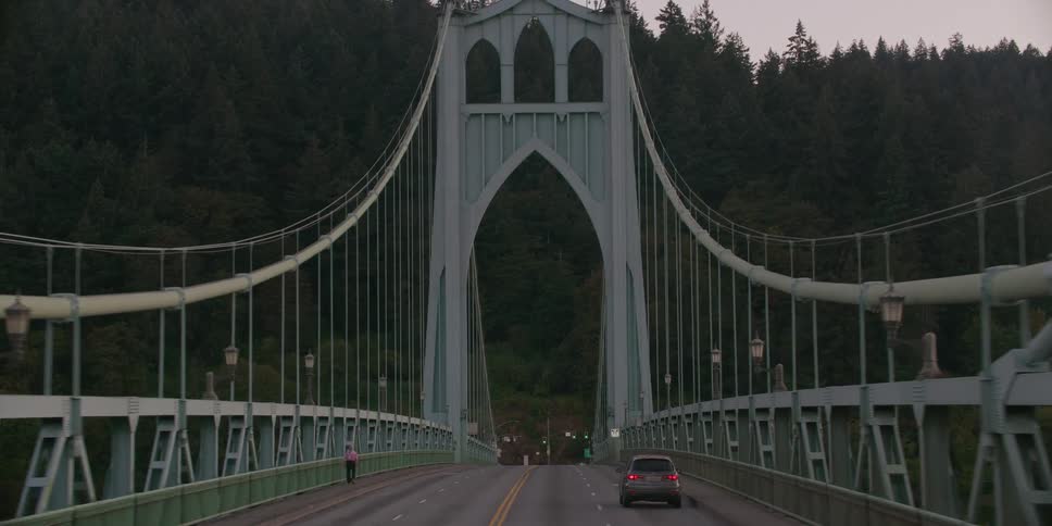 A slow, steady point-of-view drive across Portland's iconic St. Johns Bridge, with the camera moving towards its Gothic towers and tilting up to the sky
