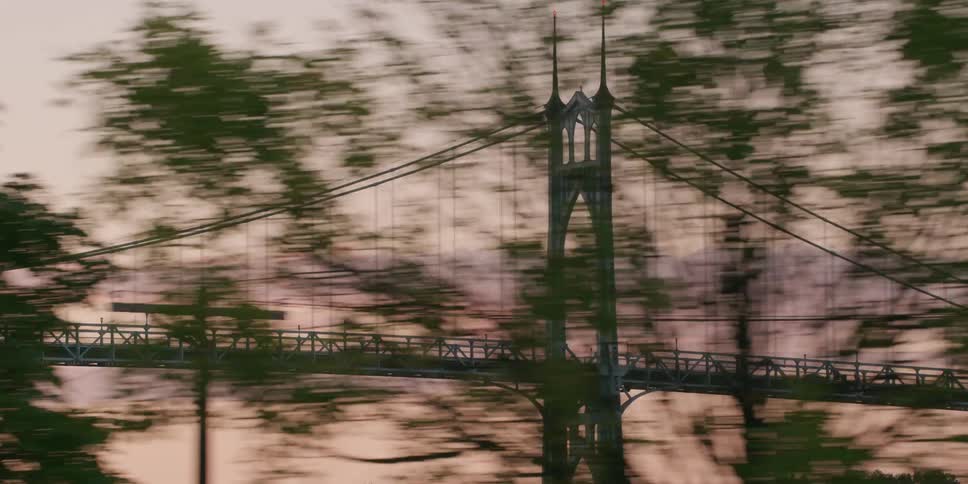 A scenic parallax view of the St. Johns Bridge in Portland, Oregon from a moving vehicle during a beautiful sunset