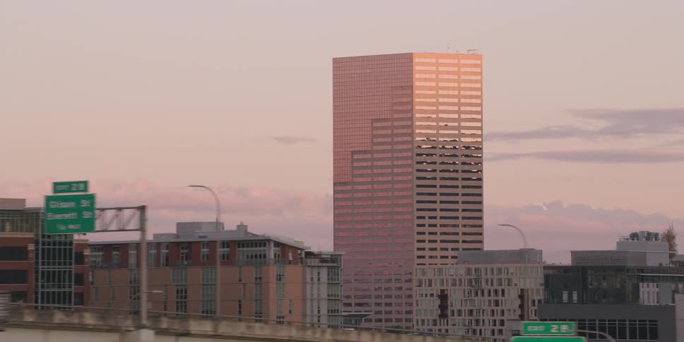 Slow-motion tracking shot of the Portland, Oregon downtown skyline and the iconic 'Big Pink' building at sunset