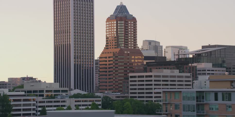 A slow aerial pan reveals the downtown Portland, Oregon skyline with its iconic skyscrapers and city buildings bathed in the warm light of sunset
