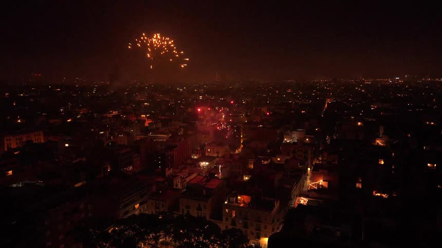 Aerial view of a vibrant fireworks display lighting up a city at night during a celebration