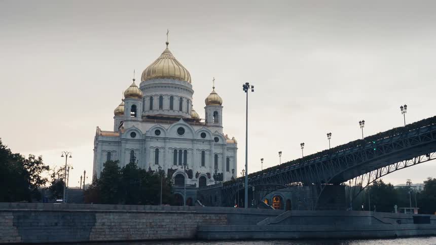 The majestic Cathedral of Christ the Saviour with its gleaming golden domes stands next to the Patriarchal Bridge over the Moskva River in Moscow