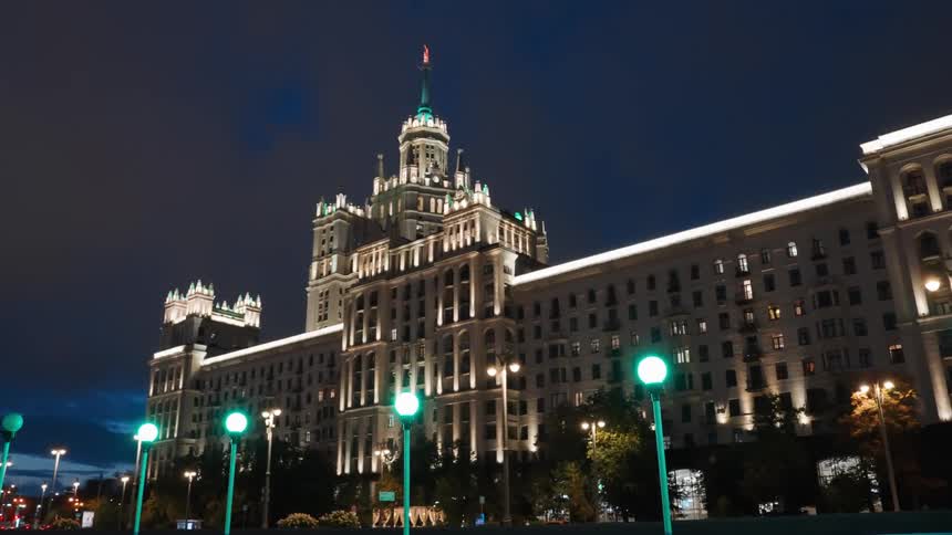 A grand historical building in Moscow, Russia, is impressively illuminated against the dark night sky