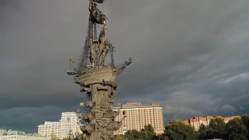 The Peter the Great Statue in Moscow stands against a dramatic, stormy sky with dark clouds overhead