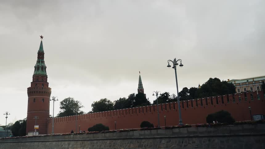 A slow, wide shot of the iconic Moscow Kremlin walls and towers under a gloomy, overcast sky