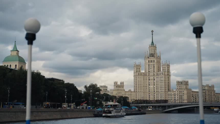 View of the historic Kotelnicheskaya Embankment Building in Moscow from a boat on the river under a dramatic cloudy sky