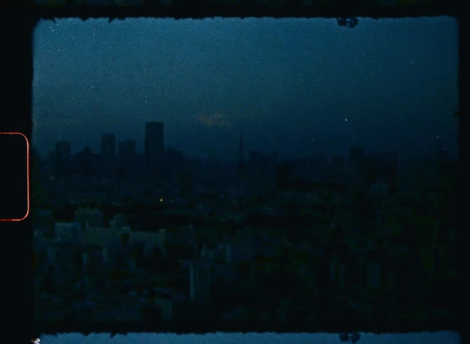 A moody and grainy vintage shot slowly zooms in on the Tokyo Tower and cityscape at night
