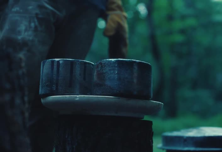 Close up of steaming, freshly fired ceramic bowls cooling on a tree stump in the woods