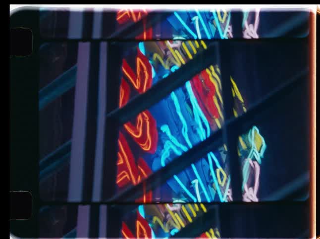 Vintage film strip animation shows abstract reflections of flickering neon signs at night