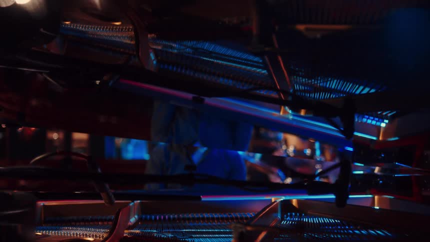 An abstract point-of-view shot pulls out from inside a stack of shopping carts, revealing a person in a hazmat suit in a dark, empty store at night