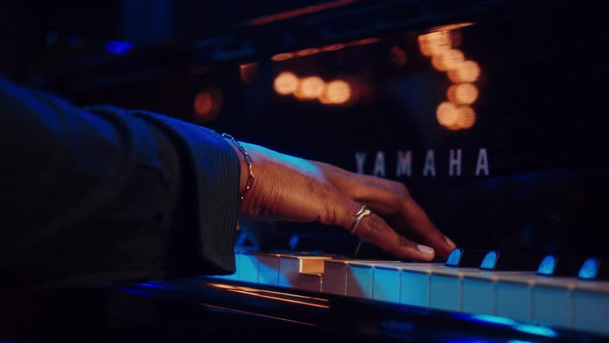 An intimate close-up shot of a pianist's hands gracefully playing a soulful melody on a grand piano in a dimly lit jazz club
