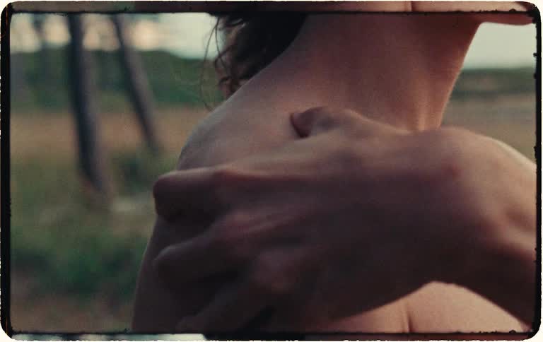 An intimate, vintage-style close-up reveals a thoughtful person being comforted with a hand on their shoulder