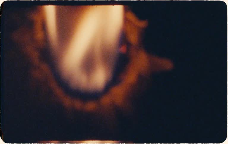 A vintage-style film burn effect shows a hole being burned through the center of the frame against a black screen