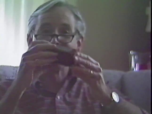 Vintage home video footage shows a grandfather happily opening a Snickers candy bar on Christmas morning