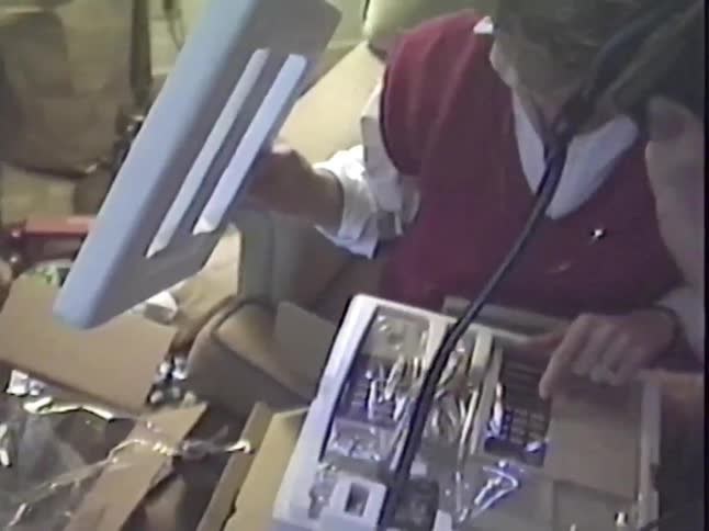A woman unboxes a new telephone system she received as a gift in a home video from the 1980s